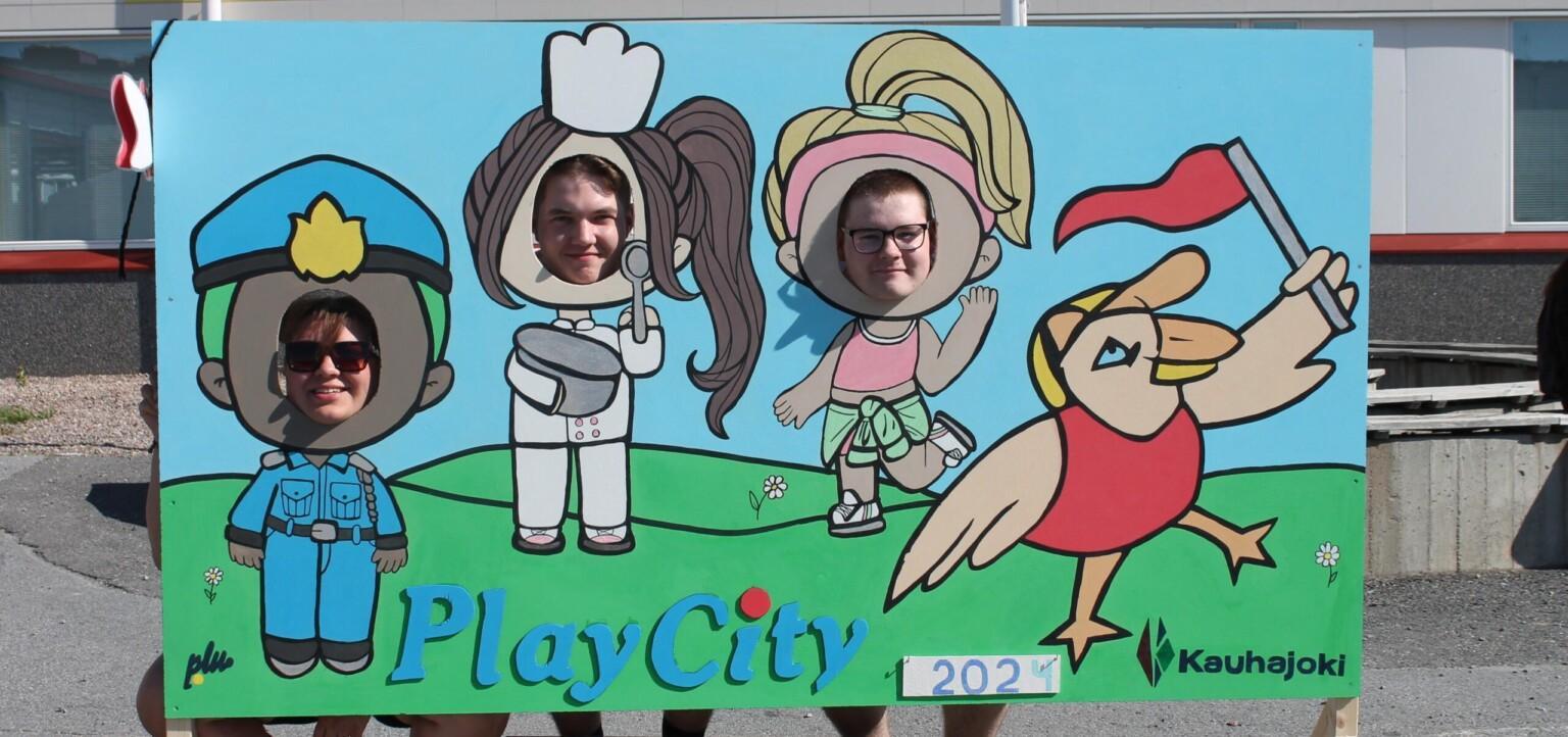 Kuvassa Playcity ohjaajia kuvausseinällä poseeraamassa.